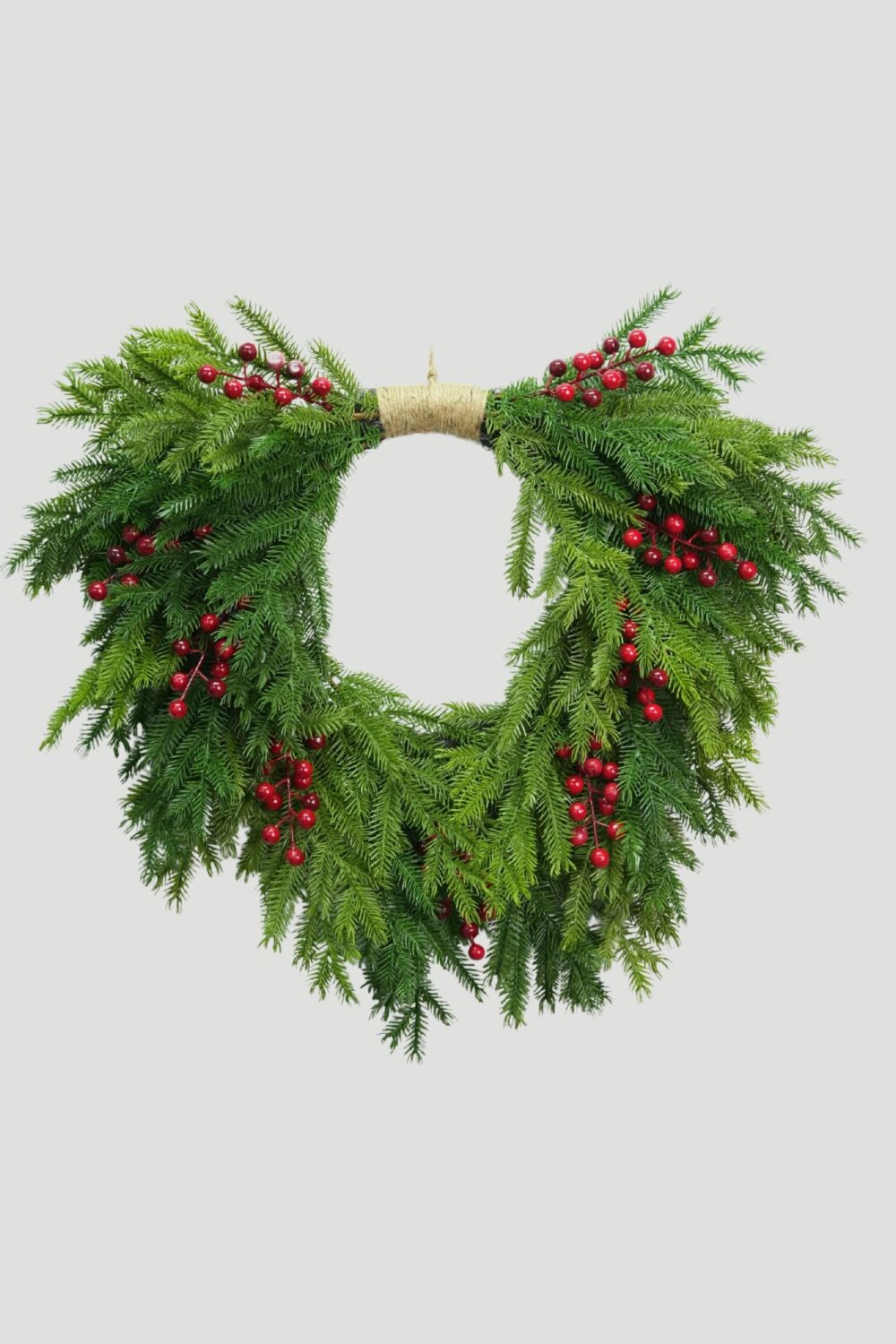 Feel Real Evergreen Hanging Wreath with Red Berries, cascading green branches, an open center and a twine-wrapped top