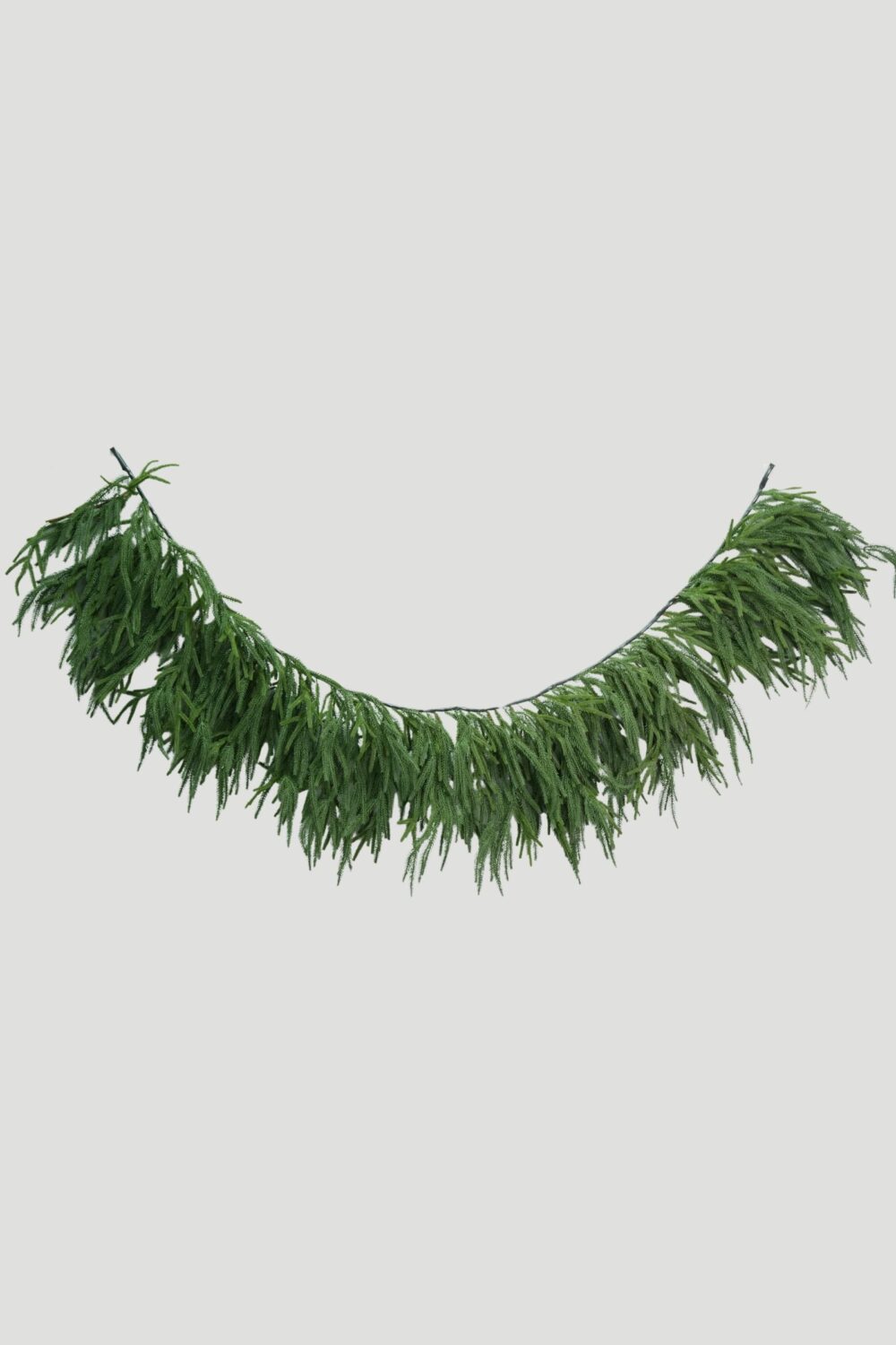 Full view of a 200cm Feel Real Norfolk Pine Mantel Garland hanging in a curved shape with cascading green branches