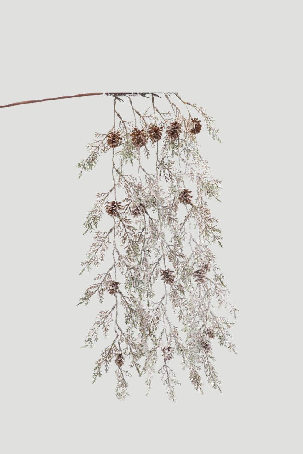 Long cascading Christmas greenery spray with frosted foliage, brown pinecones and delicate hanging branches.