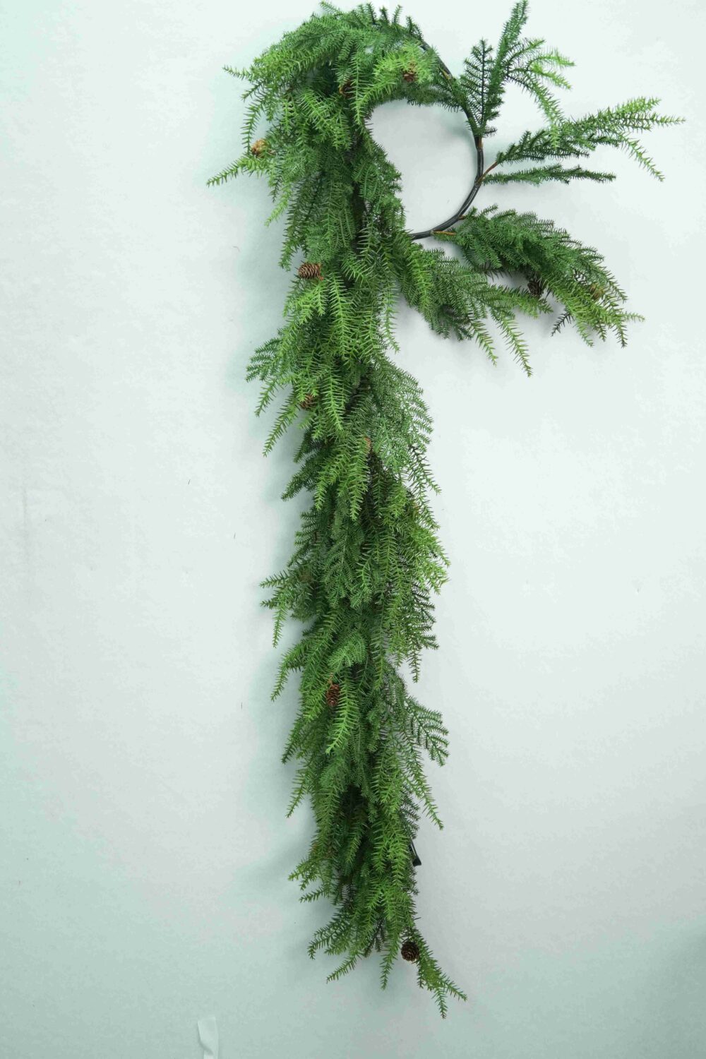 Ansicht der hängenden künstlichen Weihnachtsgirlande aus Kiefernholz mit langen, herabhängenden Zweigen und weichem, grünem Laub.